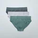 Pack de tres slips de algodón en color verde oscuro, verde y gris claro, con cintura elástica.