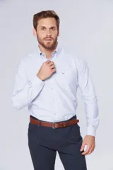 Camisa de rayas celeste, con manga larga, cuello con botones y bolsillos, diseño slim fit hasta talle XL.