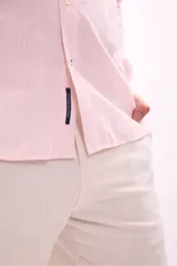 Camisa de vestir rosada de manga larga, con cuello clásico y cierre frontal con botones.