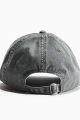 Gorra gris de sarga de algodón con ojales bordados, trabilla ajustable y cierre de metal en la parte trasera.