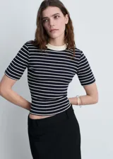 Camiseta ajustada al cuerpo, con cuello redondo y mangas cortas. Diseño a rayas horizontales azul marino y blancas, con cuello en color crema.