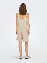 Top color crema de crochet con escote en V y tirantes anchos.