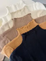 Polera de cuello alto con volados en el cuello, de tejido de punto fino en colores blanco, beige, marrón, mostaza y negro.