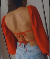 Body blanco con escote corazón, mangas largas abullonadas y espalda abierta con tiras para atar.