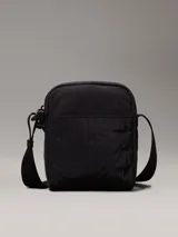 Cartera de hombre en color negro, de poliéster reciclado, con correa ajustable y cierre de cremallera.