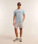 Remera deportiva celeste de poliéster con tecnología Dry, cuello redondo y mangas cortas. Estampa geométrica horizontal en el pecho y recortes en las mangas.