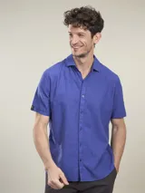 Camisa de manga corta azul con cuello clásico y cierre con botones.