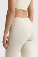 Calza larga color crema de corte alto, con cintura alta y pretina ancha.