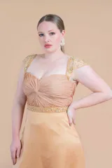 Vestido de gasa de seda natural color oro, con corsé drapeado y mangas de tul bordado.