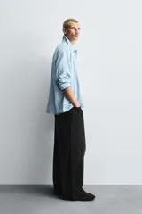 Pantalón de jeans de algodón, corte baggy fit, tiro medio, con efecto lavado en tonos grises y verdes. Presenta cinco bolsillos y cierre frontal con cremallera y botón.