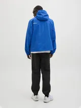 Campera azul de nylon con capucha, cierre frontal con cremallera, bolsillos delanteros y puños elásticos.
