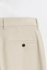 Pantalón slim fit negro confeccionado en tejido con elasticidad en ambas direcciones. Cuenta con bolsillos frontales y traseros de vivo con botón. Cierre frontal con cremallera y botón.