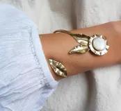 Brazalete delicado hecho a mano en bronce con detalles de nácar, diseño floral y medida estándar.
