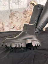 Bota de cuero negra de media caña con plataforma y suela track.