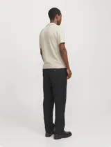 Polo de punto color beige con cierre de cremallera, cuello polo y mangas cortas.