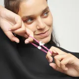 Pulsera de hilo elástico doble color rosa vibrante, con un dije central de corazón plateado de apariencia tridimensional y un cierre de bola metálica plateada.