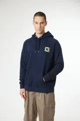 Hoodie azul marino con capucha, bolsillo canguro y cordones ajustables. Presenta un pequeño parche cuadrado amarillo con una 'X' y texto en japonés en el pecho.