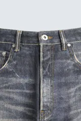 Pantalón de jean azul con lavado gastado, corte holgado y cinco bolsillos.