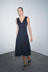 Vestido midi azul marino confeccionado en hilatura con algodón. Escote pico y tirantes anchos. Bajo evasé. Cierre frontal con cremallera metálica.