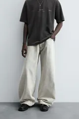 Pantalón de jean negro de corte amplio, estilo balloon fit, con cinco bolsillos y cierre frontal con botones.