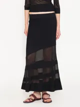 Pollera larga negra de tejido de punto con organza transparente en la parte inferior.