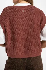 Chaleco de punto color beige con lurex, de corte recto y mangas cortas. Tejido calado con pequeños agujeros.