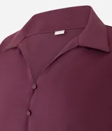 Blusa color borgoña de viscosa texturizada, con cuello, abotonada al frente, mangas cortas con dobladillo y lazo en la cintura.