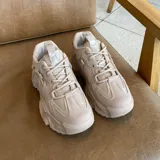 Zapatillas de mujer color beige, con diseño grueso y suela alta.