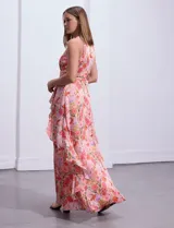 Vestido largo de gasa estampada con flores, escote halter, busto plisado, corte en la cintura con faja plisada, falda delantera con sobrecapa y abertura central en la espalda con cierre invisible.