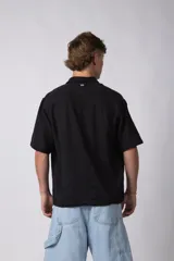 Camisa de lino color blanco, de manga corta, con cuello clásico y cierre frontal con botones.