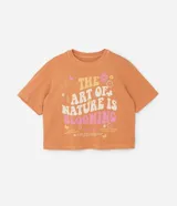 Remera color durazno de corte cuadrado con cuello redondo y mangas cortas. Estampa frontal con flores y la frase "The art of nature is blooming".