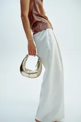 Bolso de mano ovalado color dorado con asa metálica plateada y cierre de cremallera.