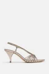 Sandalia de tacón fino color dorado, con tiras finas cruzadas en el empeine y tobillo.