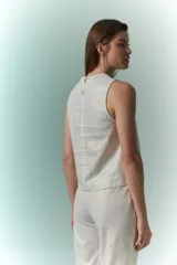 Top sin mangas de lino metalizado color beige, con cuello redondo y detalle trenzado en el borde.