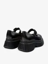 Zapato tipo Mary Jane color negro, con correa con hebilla y plataforma con suela track.