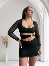 Minivestido negro con escote cuadrado, mangas largas de tul y aberturas en la cintura unidas por aros metálicos.