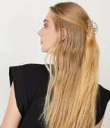 Pinza de pelo dorada con forma de concha hueca.