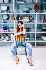 Zapato de tacón turquesa con diseño en escamas y flor naranja en la punta. Tacón de 6,5 cm, plantilla celeste, interior de piel y suela de cuero. Fabricado en España.