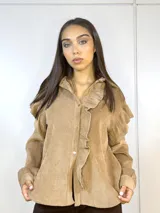 Camisa beige de pana fina con volados en los hombros y botones dorados.