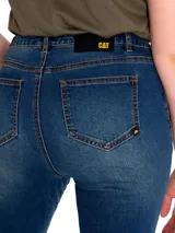 Pantalón de jean celeste claro con rotura en la rodilla, corte recto y diseño de cinco bolsillos.