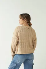 Sweater tejido con trama de ochos color fucsia, cuello redondo y corte cropped.