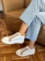 Championes urbanos blancos con detalles en cuero color tostado en la puntera, laterales y talón.