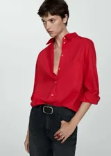 Camisa roja oversize de algodón con cuello camisero, manga larga abotonada, bolsillo de parche en el pecho y cierre frontal con botones.