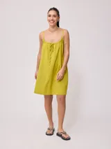 Vestido corto de algodón y lino color negro, con tirantes finos y escote recto con lazo ajustable.