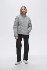 Campera puffer estampada a cuadros en blanco y negro con pequeños corazones rosados, cierre frontal con cremallera y bolsillos laterales.