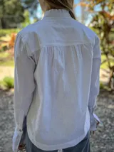 Camisa de lino y algodón blanca, con tablas en el escote y mangas largas.