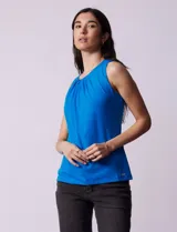 Blusa azul sin mangas, con cuello redondo con frunces delanteros y abertura con botón en la espalda.