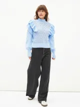 Sweater lila de tejido calado con cuello alto y mangas largas abullonadas con volados.