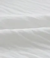 Blusa blanca de crepé con escote en V, abotonada en el frente y mangas cortas abullonadas.