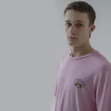 Remera blanca de algodón con estampa en la espalda de una combi amarilla con llamas saliendo del escape, dentro de un óvalo con el texto "Pulau & Co.".
